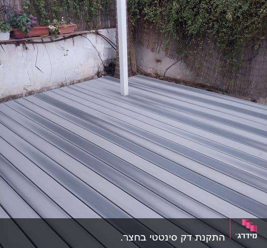 דק עץ בגינה עם צמחייה מסביב
